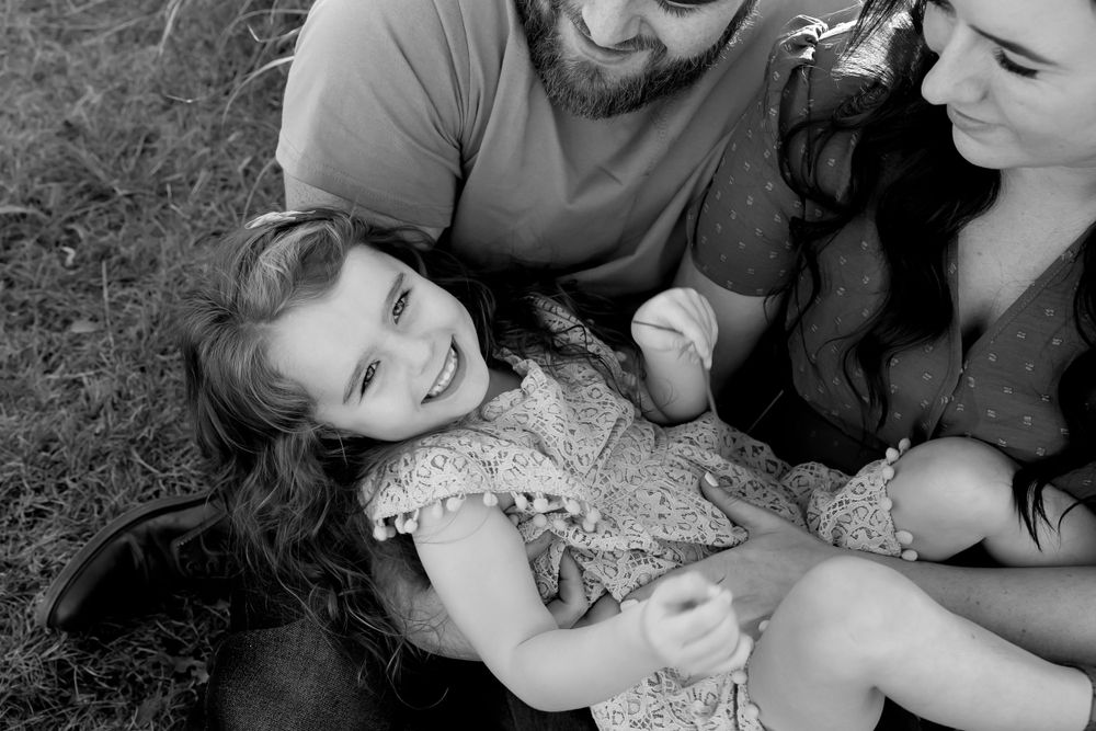 A joyful black and white portrait of a family sharing a tender moment together.