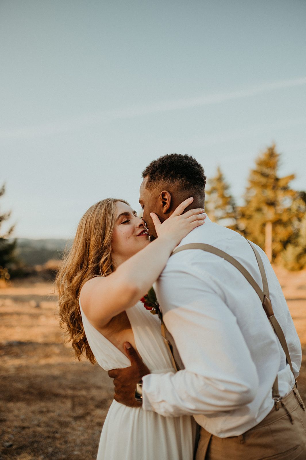 Romantic sunset moment captured between newlyweds in an outdoor setting.