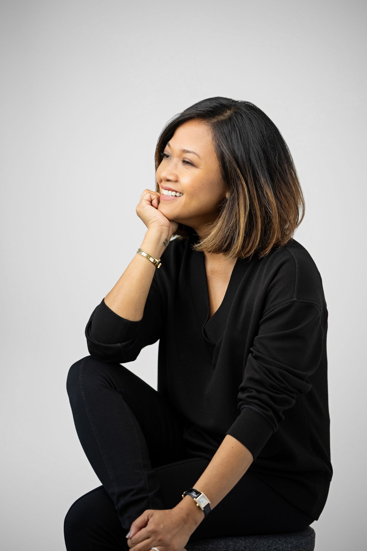 Series of casual portraits in black outfit against white background showing candid expressions.