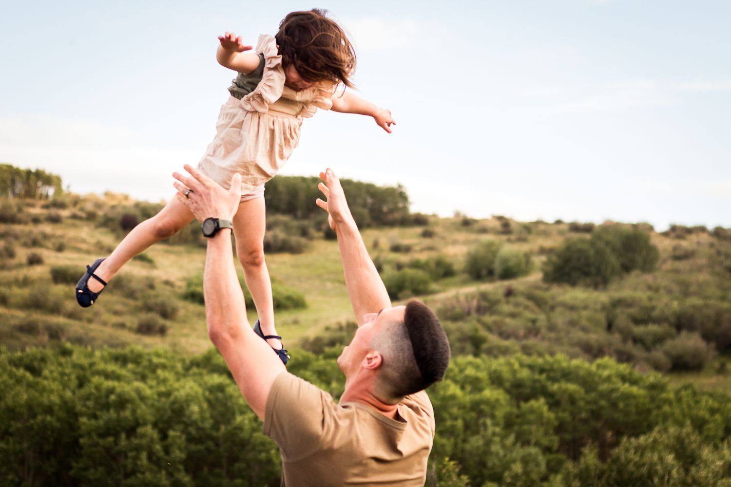 Daddy daughter moment during family photos at Nose Hill Park in summer.