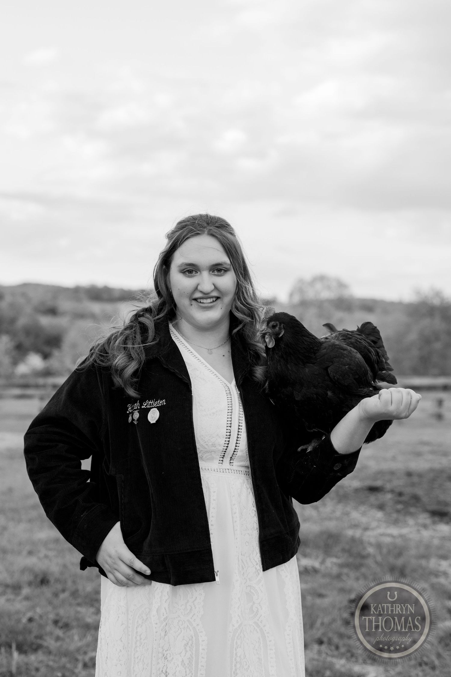 A black and white portrait featuring a posed figure in navy jacket with a black chicken.
