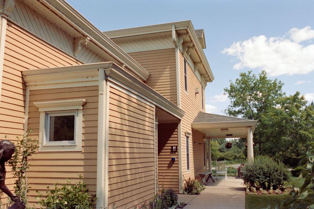 Architectural details of a tan colored house showing siding, windows and trim work.