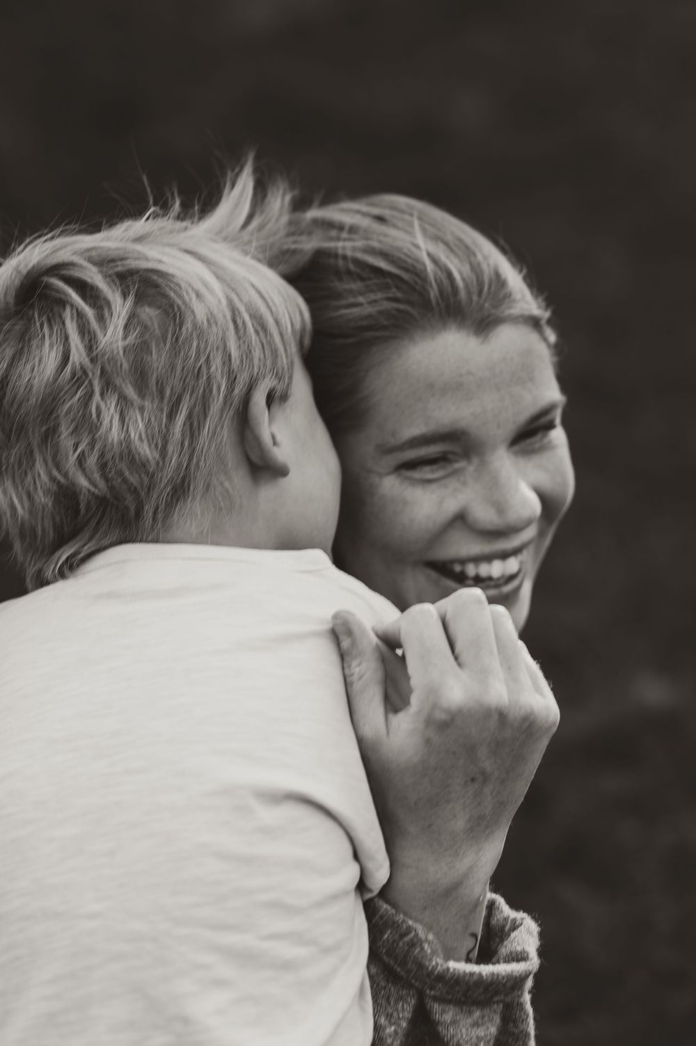 An intimate black and white portrait capturing a tender moment between parent and child.