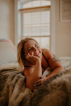 Cozy indoor portrait session with warm golden hour lighting through window.