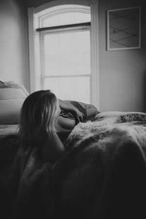 Monochrome bedroom photography with arched window and minimal wall art.