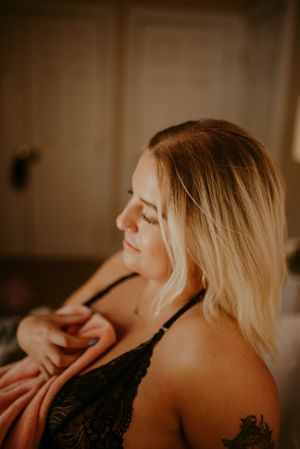 Warm-toned boudoir portrait with soft natural lighting and lace details.