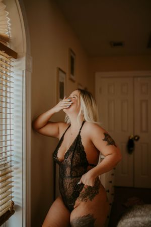 Playful boudoir portrait showing genuine laughter and natural movement.