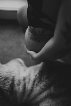 Artistic black and white boudoir photo with soft focus on lingerie details.