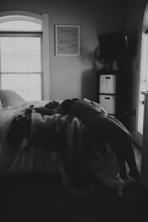Moody black and white bedroom scene with window light and soft shadows.