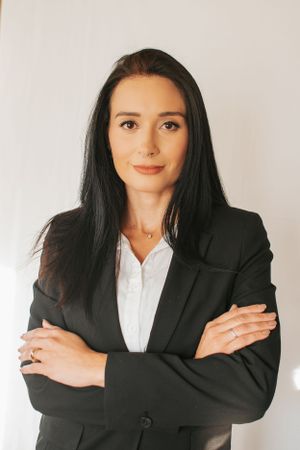 Professional studio portrait in classic black blazer and white button-up shirt.