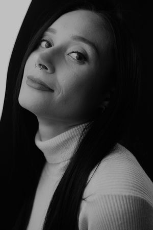 Dramatic black and white portrait with side lighting and textured sweater.