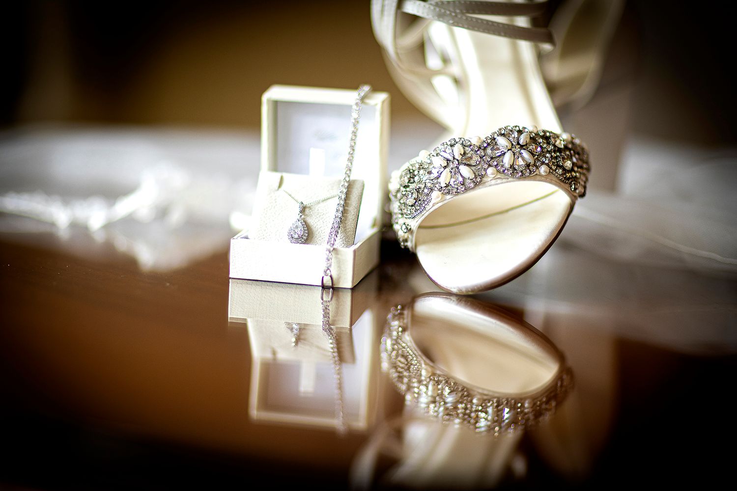 bride's shoe and necklace on a table at whittlbury park Northamptonshire wedding photography