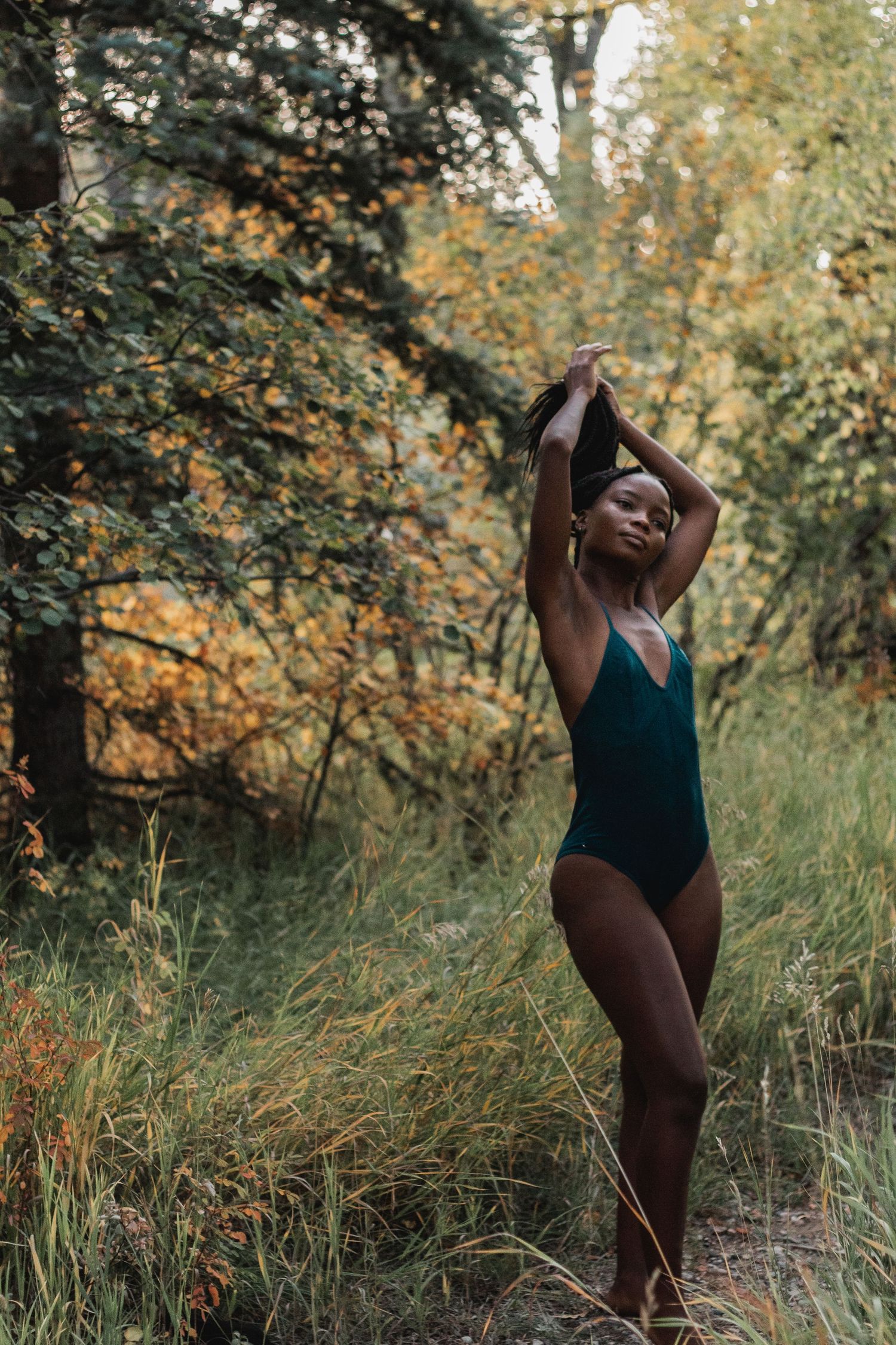 Dynamic outdoor photoshoot featuring expressive poses in a natural woodland setting.