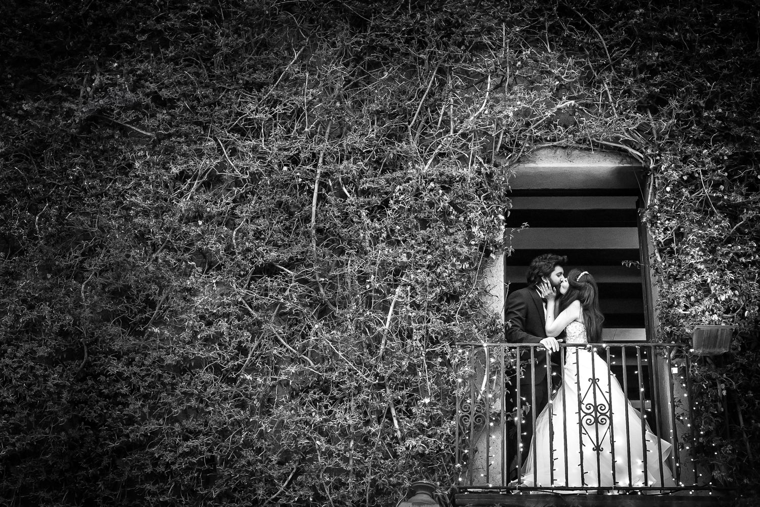 Bride and groom kissing on the balcony