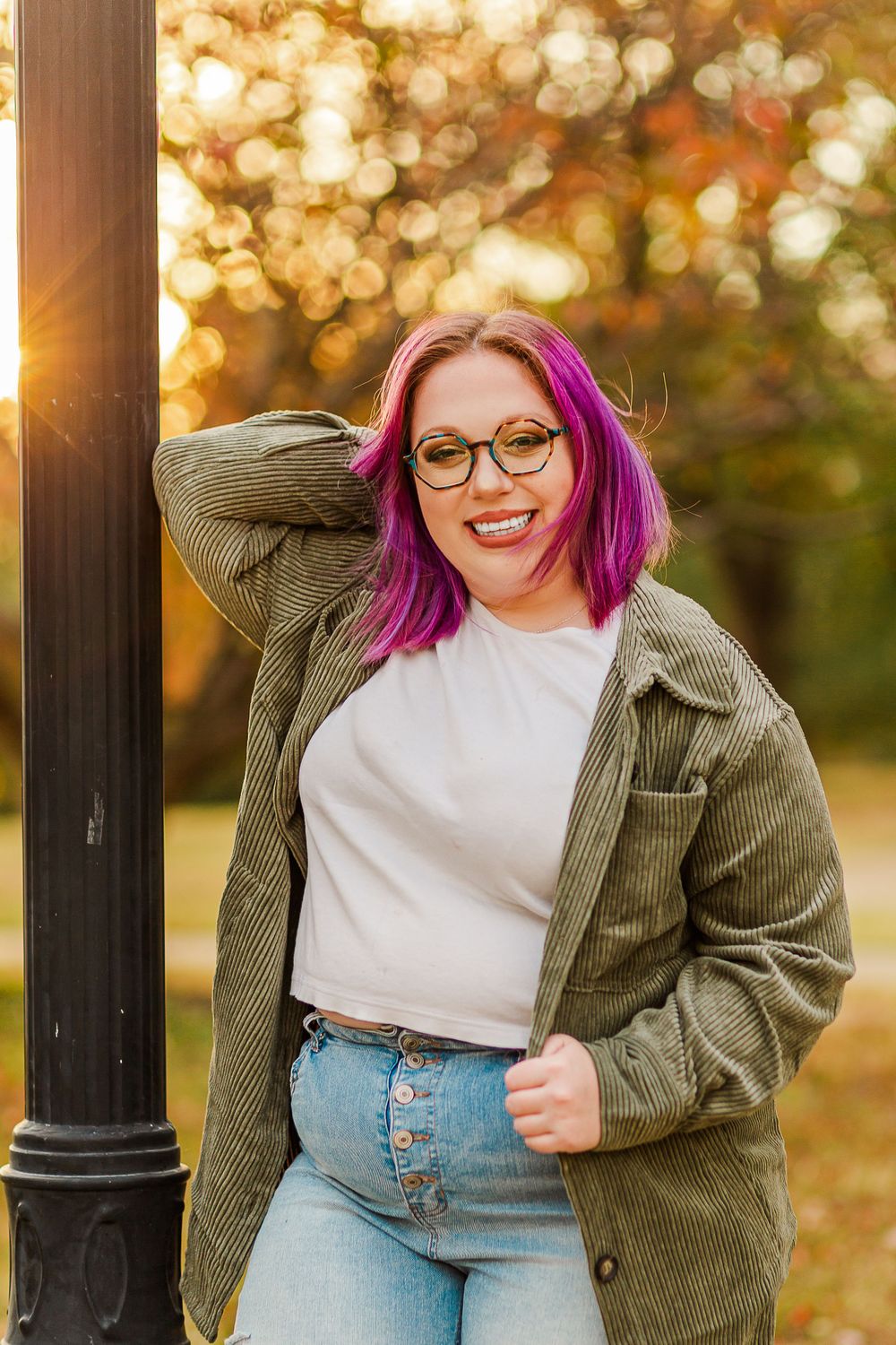 Stylish outfit featuring olive corduroy jacket, white top and jeans during golden hour autumn photoshoot.
