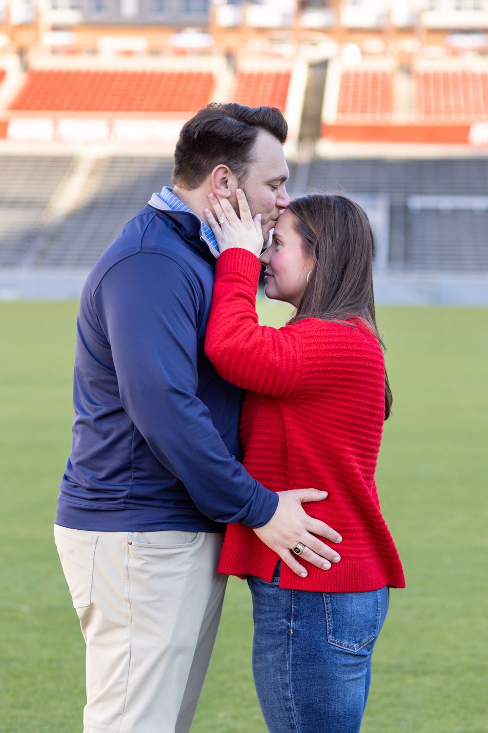 A man kisses his new fiancé on the forehead at their Raleigh, NC proposal photoshoot.