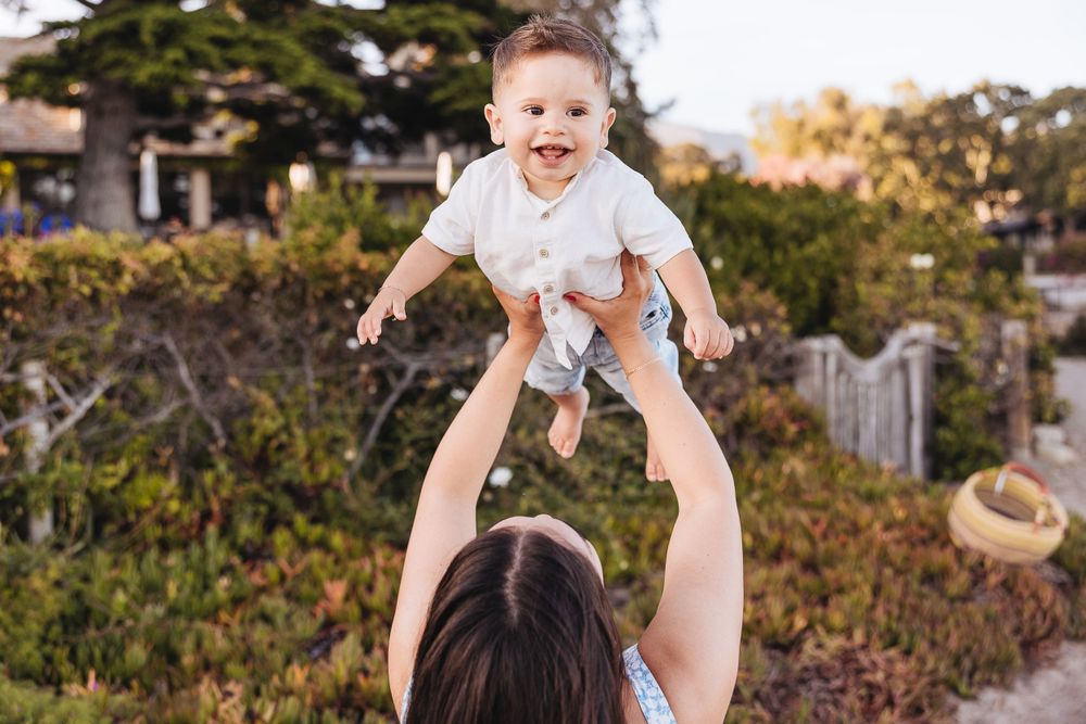 A joyful moment of lifting and playing against a garden background.