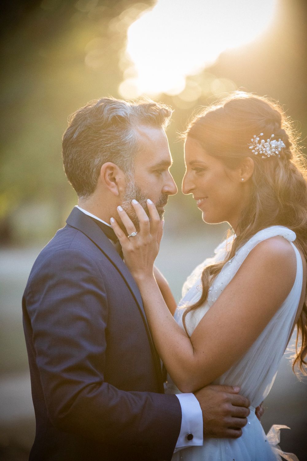 Intimate sunset portrait of newlyweds sharing a tender moment.