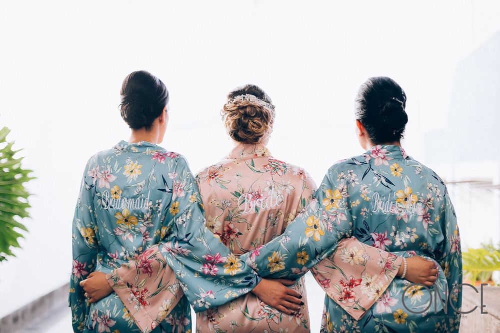Three floral silk robes shown from behind with intricate Asian-inspired patterns.