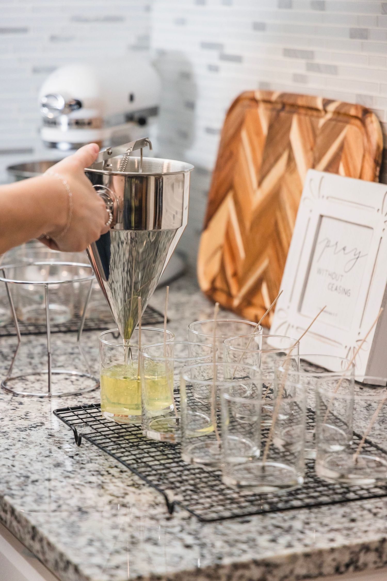 Crystal glasses and cocktail mixing setup on granite countertop with copper accents.