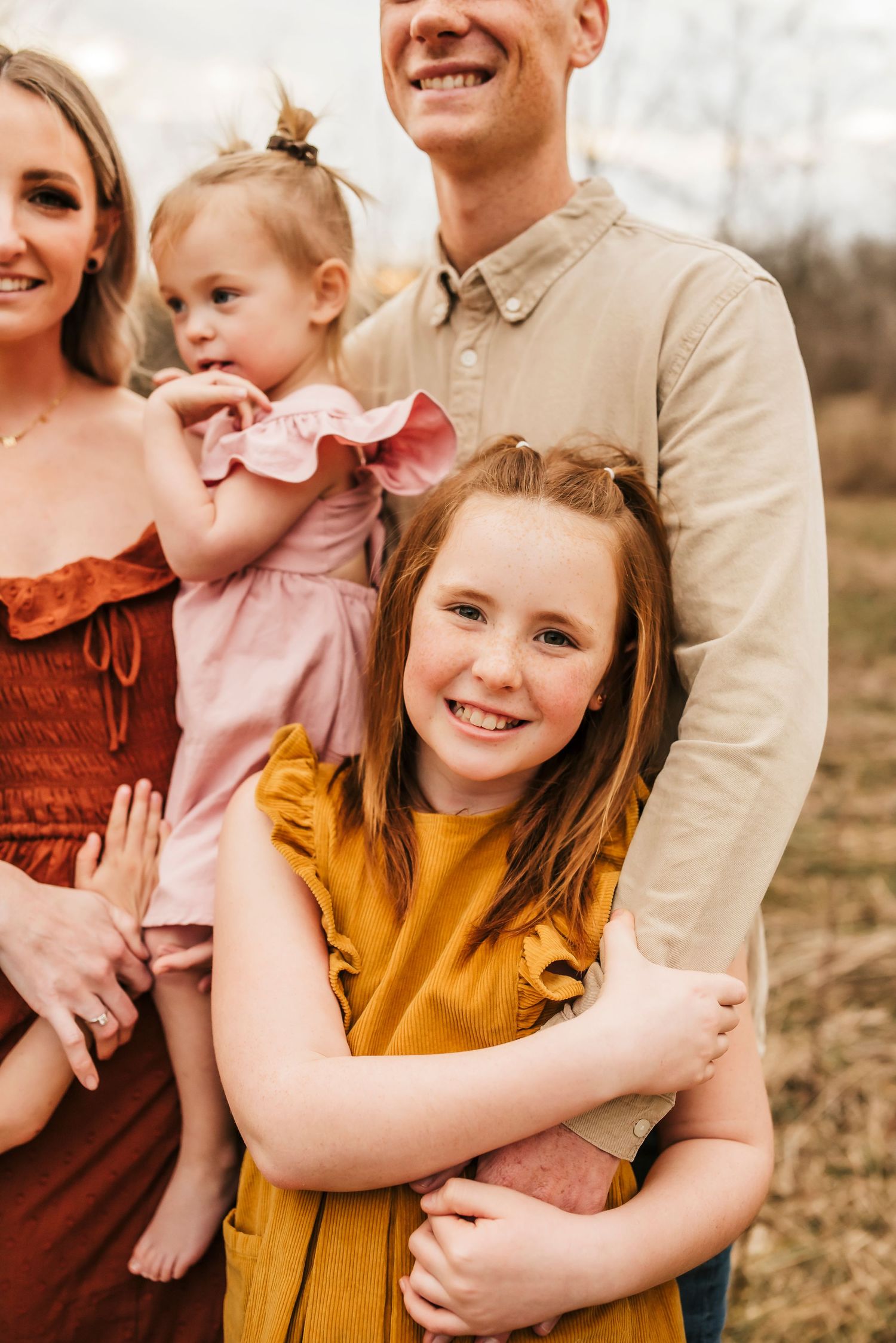 red headed daughter hugs dads arm