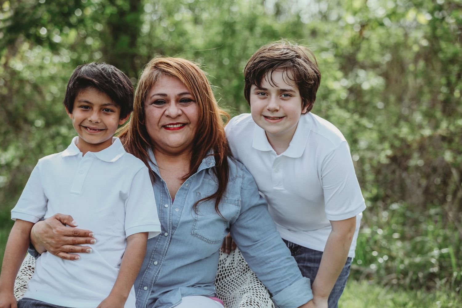 Family group wearing coordinated blue and white outfits posing together outdoors on grass.