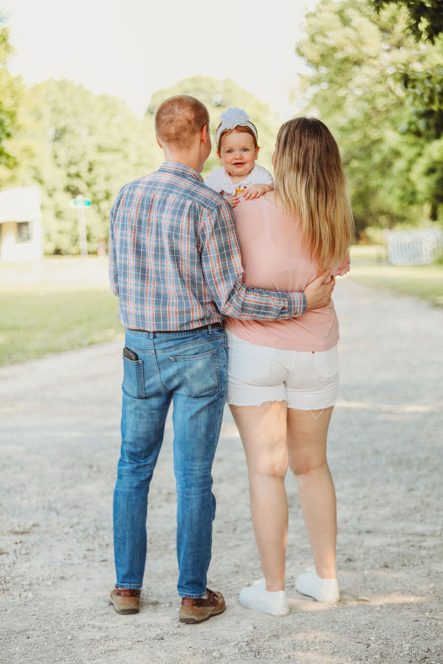 Walking feet of family members on a gravel path in casual summer attire.