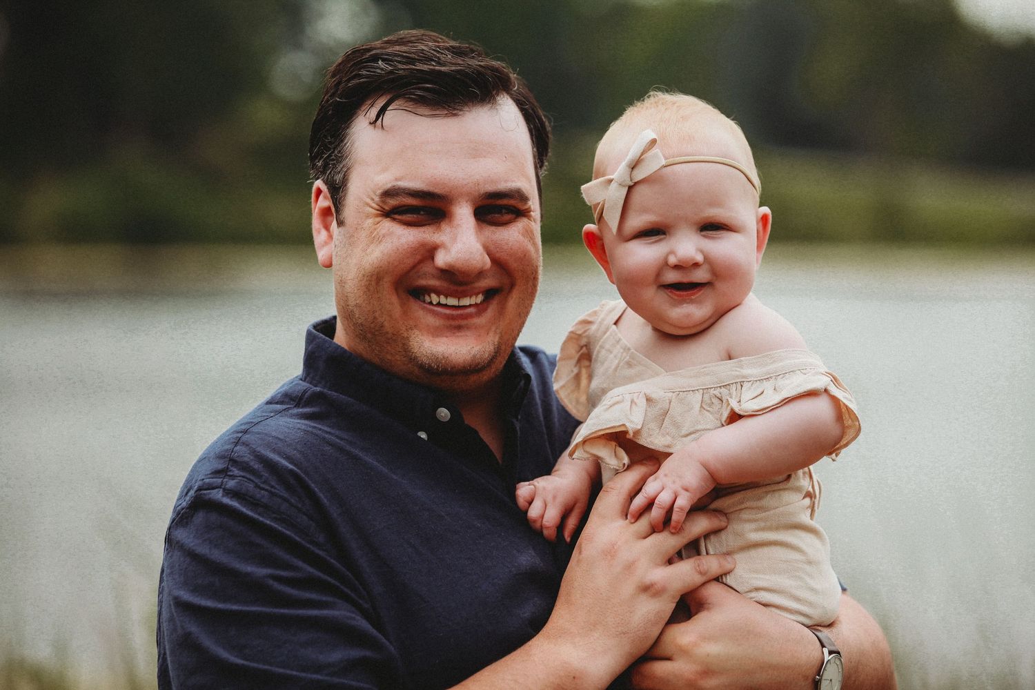 Heartwarming outdoor portrait by a lake showing pure joy and connection.