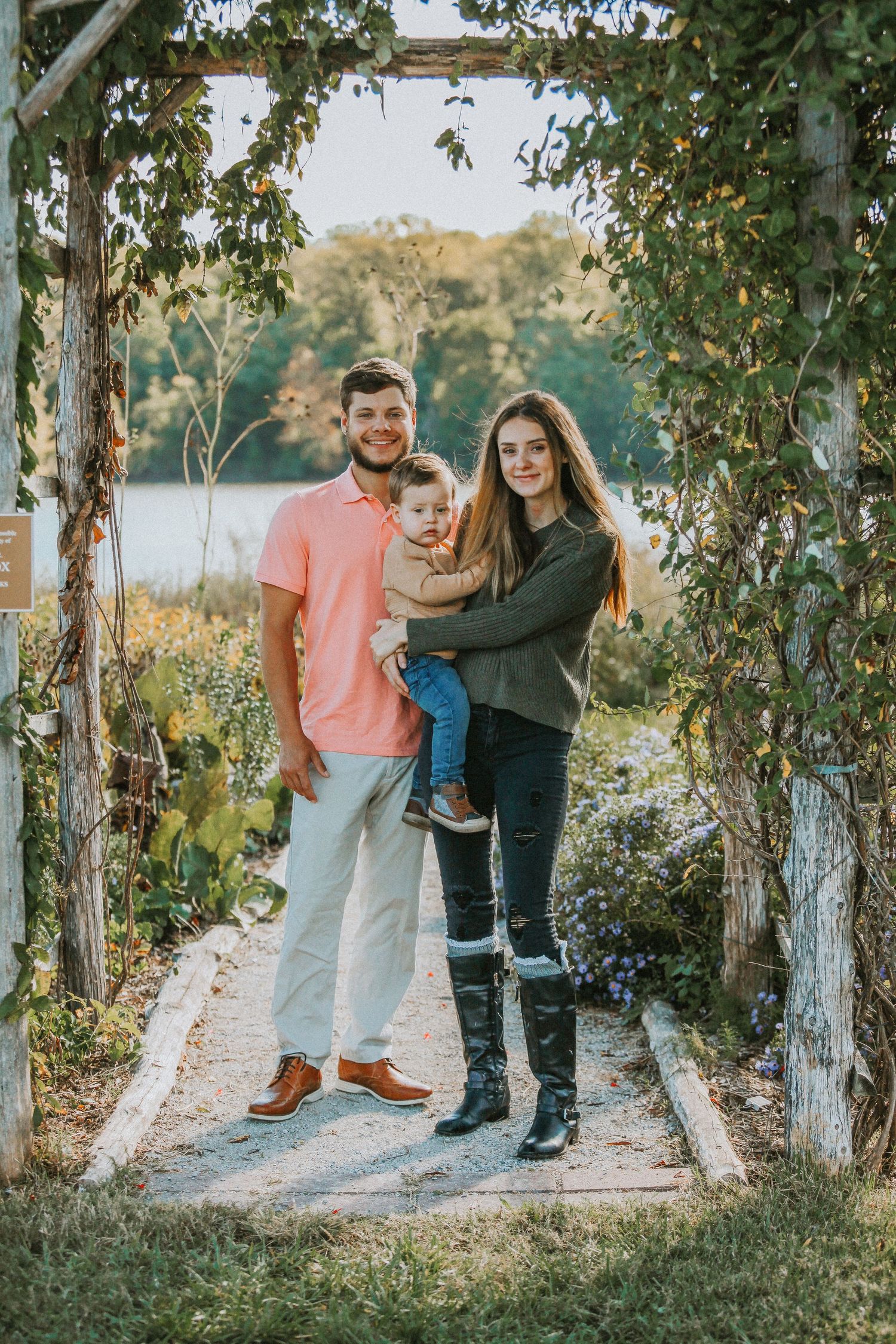 A family walking together on a tree-lined path during golden hour.