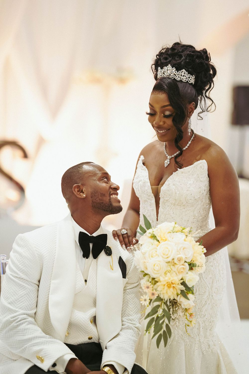 Intimate wedding portrait captures joyful moment between newlyweds with elegant floral bouquet.