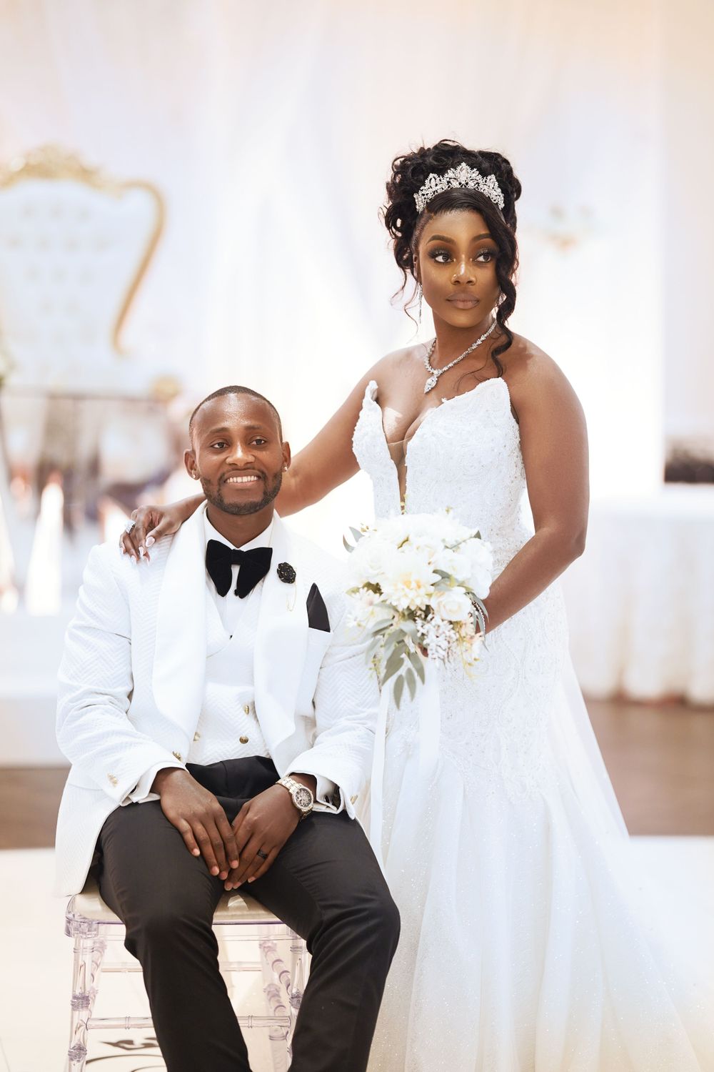 Wedding couple sharing intimate indoor portraits in elegant white attire.