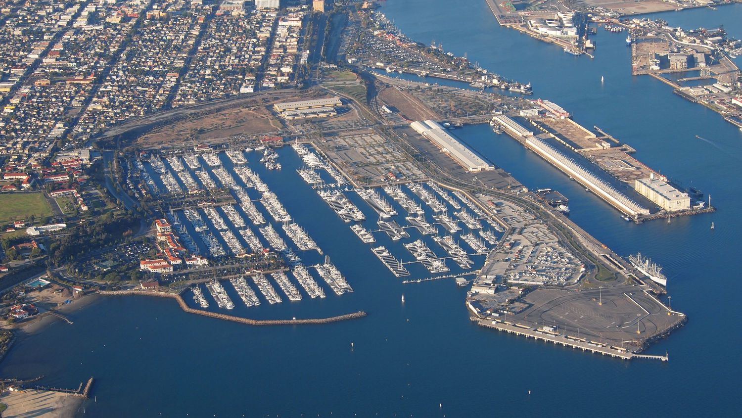 Aerial view of a large marina with hundreds of boats docked near an urban waterfront and harbor.