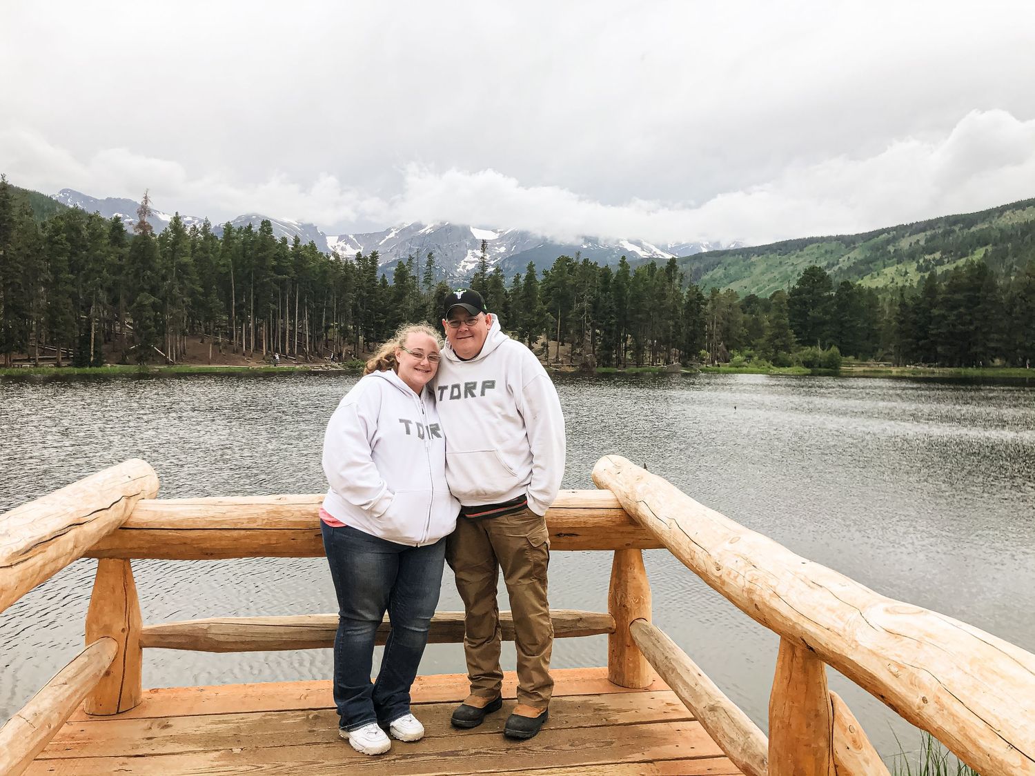 Husband and wife standing on a pier in Colorado