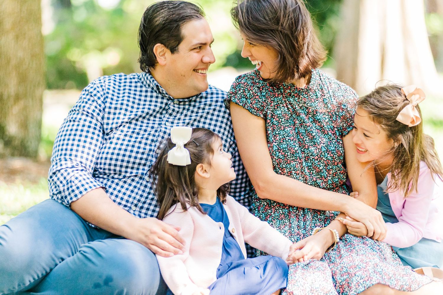 A family shares a candid moment of joy and laughter while sitting together outdoors.