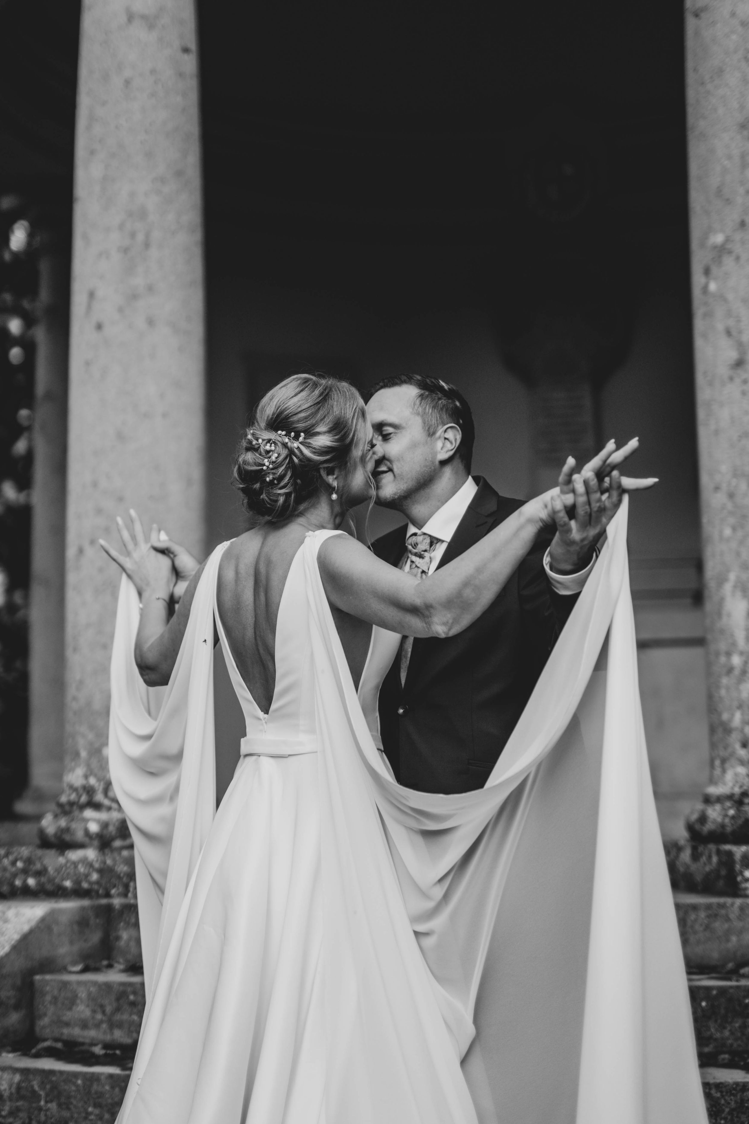 Romantic dance sequence captured in black and white among stone pillars.