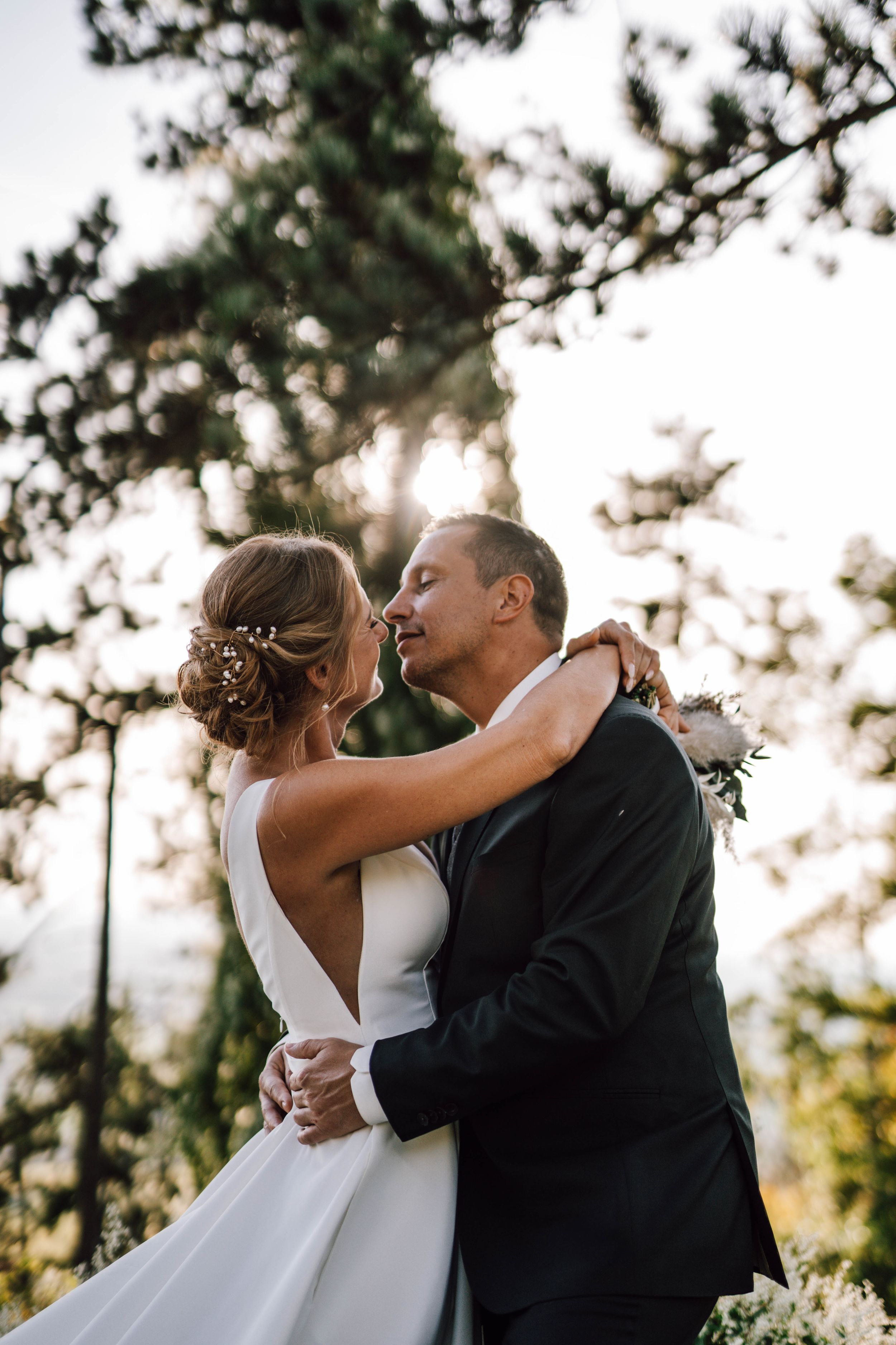 Golden hour wedding portrait with couple embracing in sunset light.