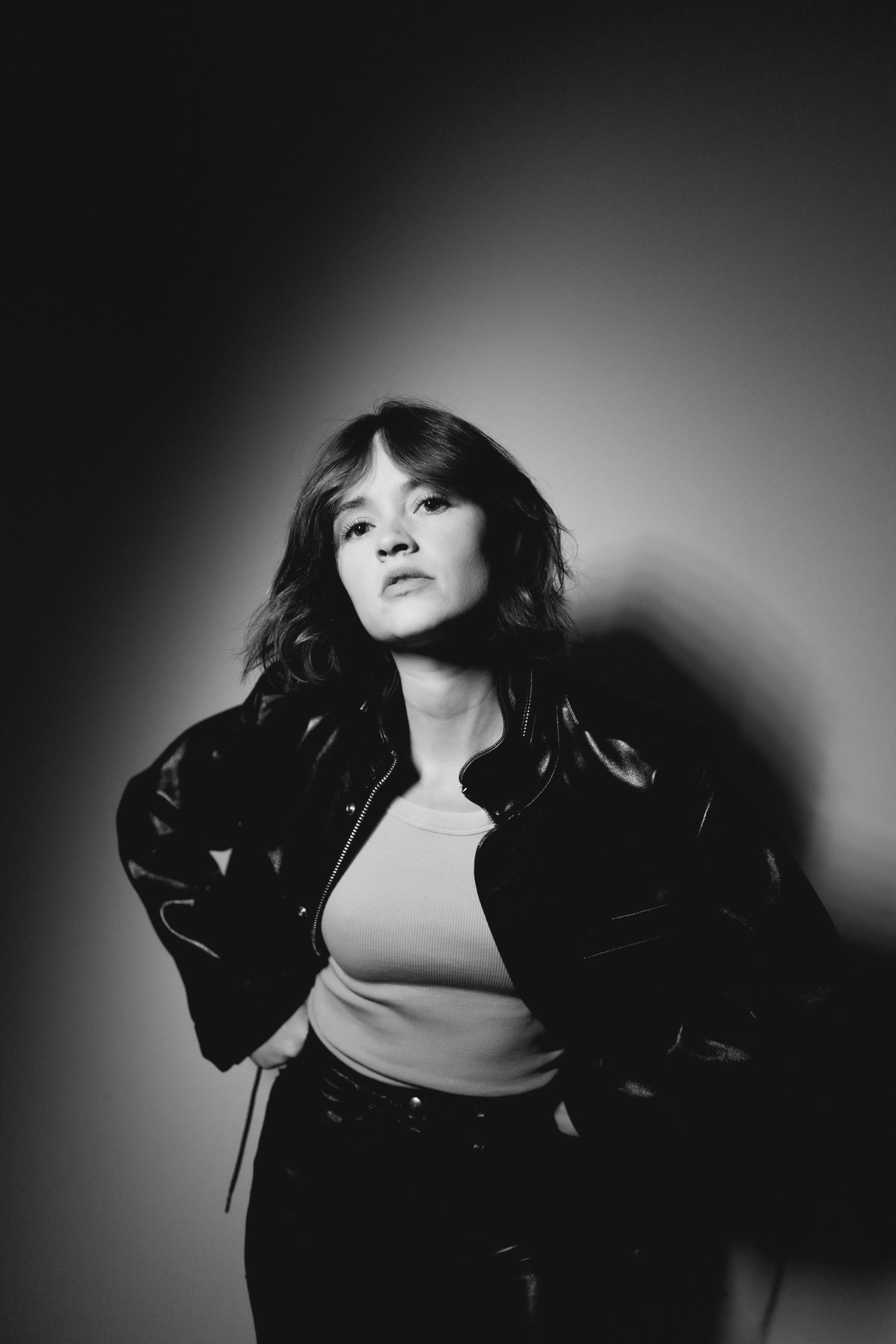 Moody black and white portraits in leather jacket with dramatic lighting.