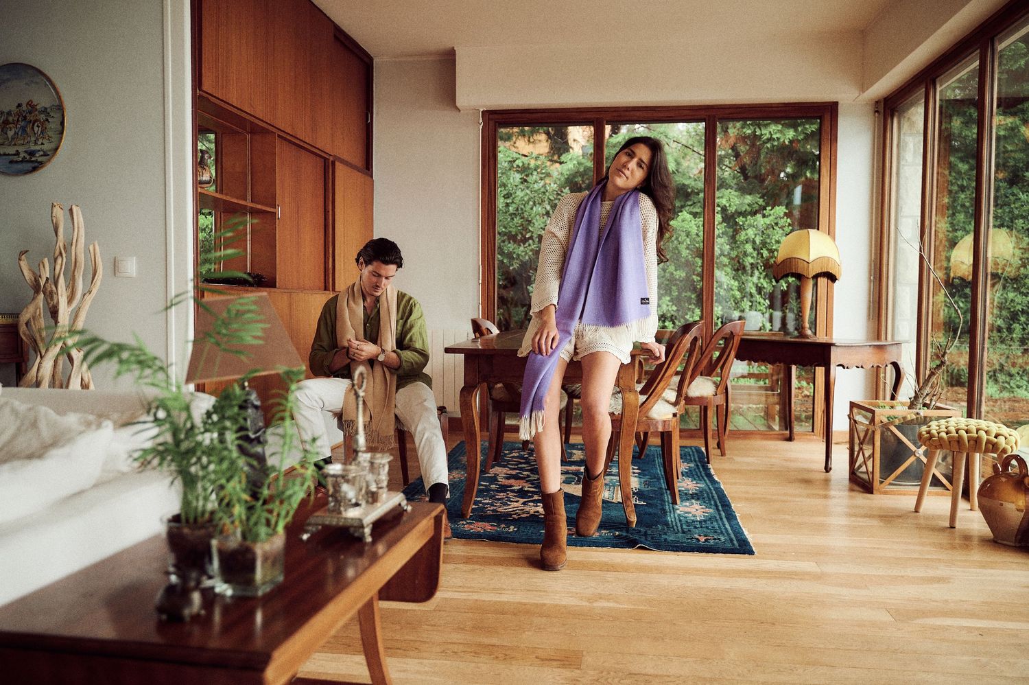 Interior fashion shoot in a modern room with large windows and natural lighting.