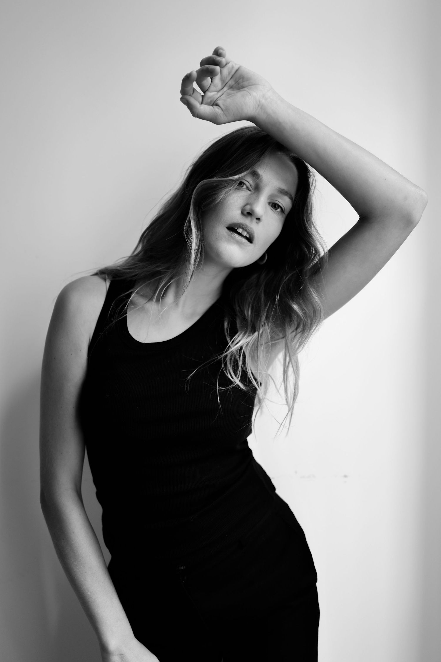 Artistic black and white portrait series showing expressive poses against white backdrop.