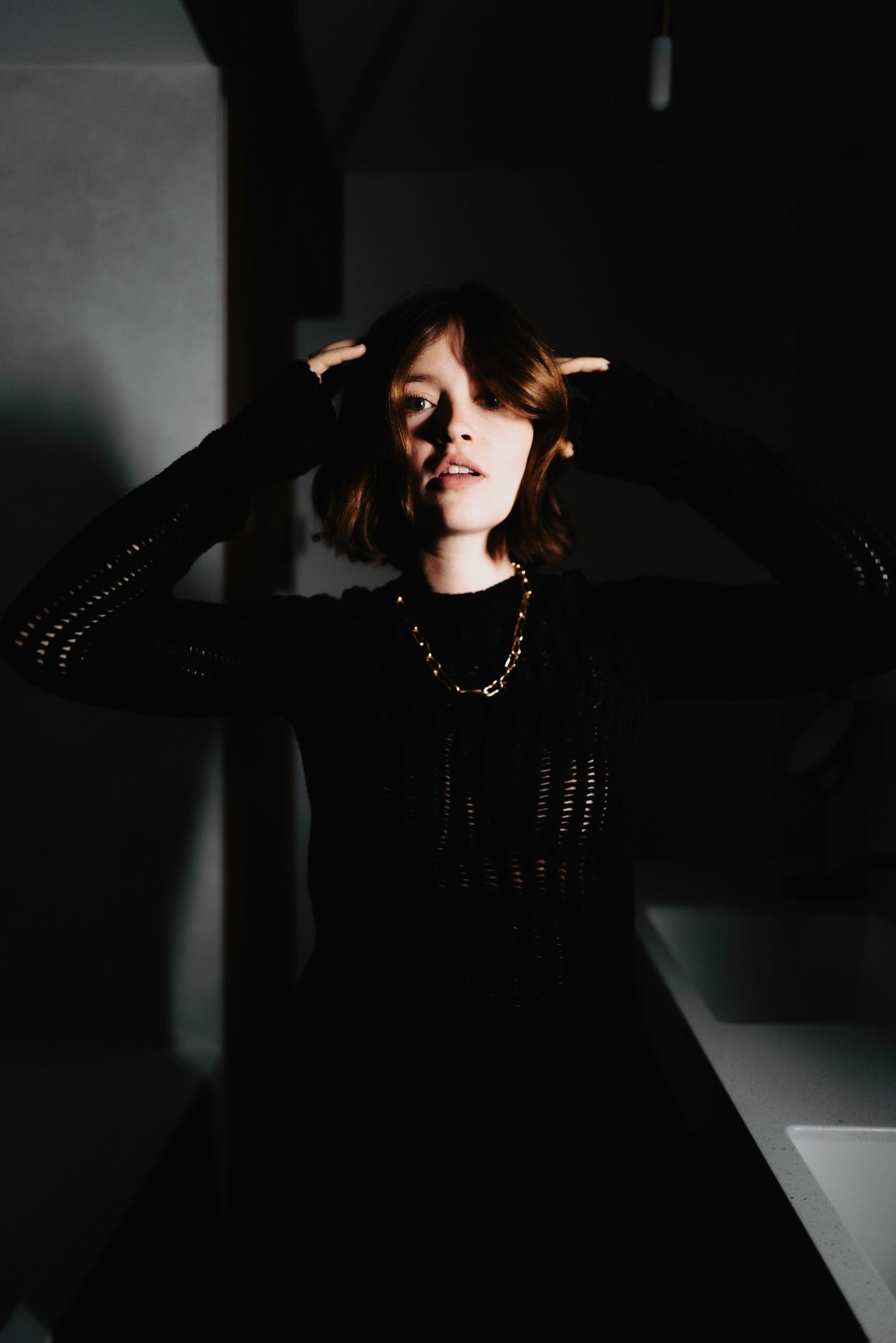 Artistic low-key photography sequence showing a figure in black against dramatic shadows.