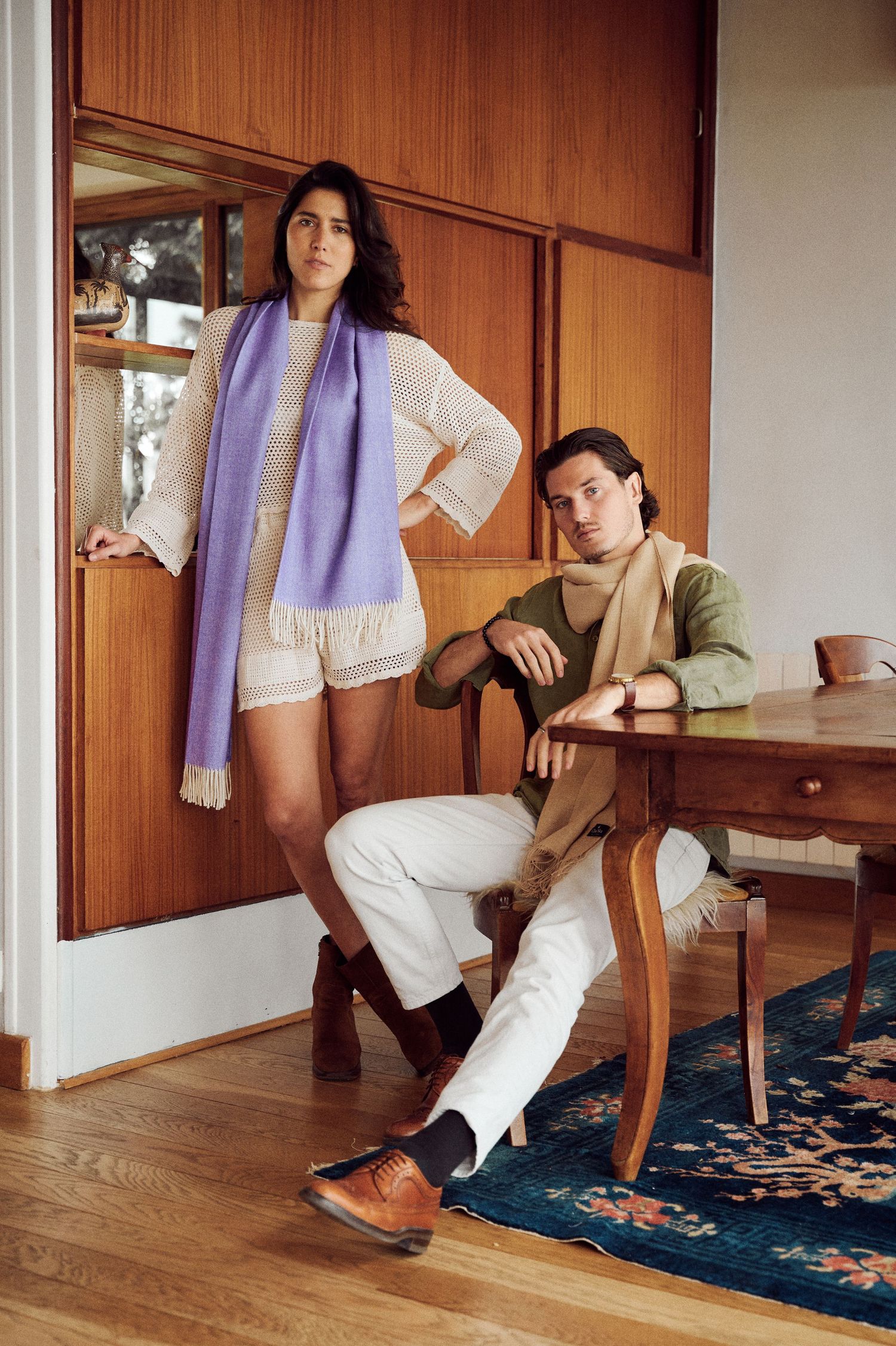 Styling sequence with white outfit, purple scarf and brown boots on oriental rug.