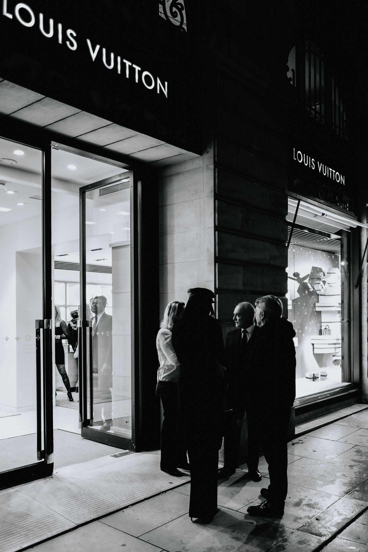 Black and white exterior shots of a Louis Vuitton storefront with people silhouettes.