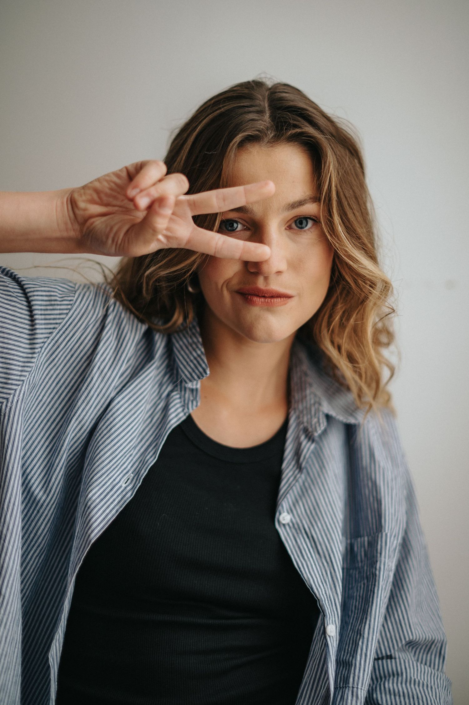 Playful portrait sequence with striped jacket and expressive hand gestures.