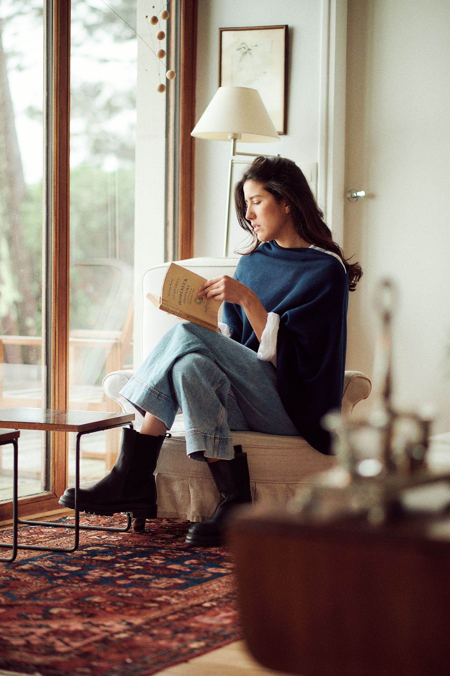 Artistic photo sequence showing relaxed poses on a patterned rug by large windows.