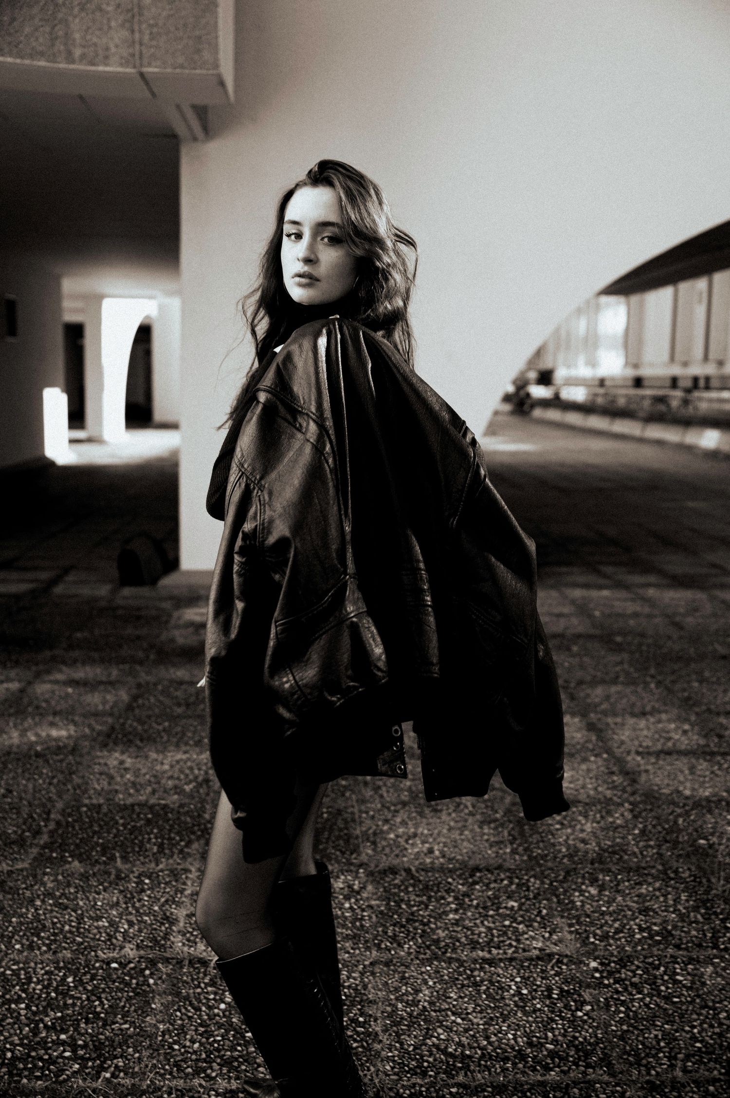 Monochrome fashion series shot in an urban setting with dramatic shadows.