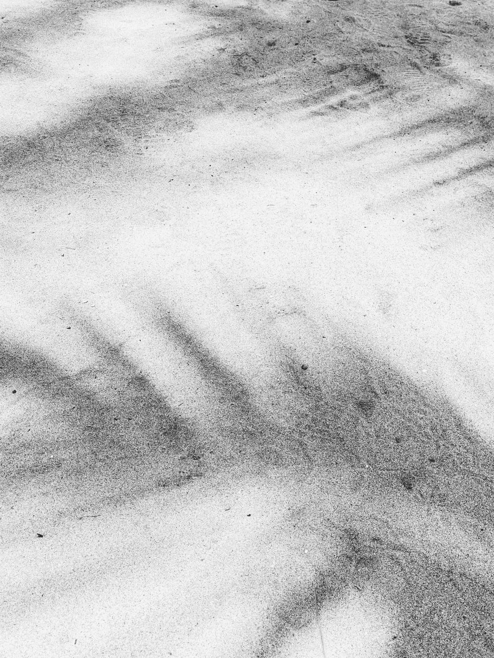 Abstract black and white texture of sand patterns on a beach.