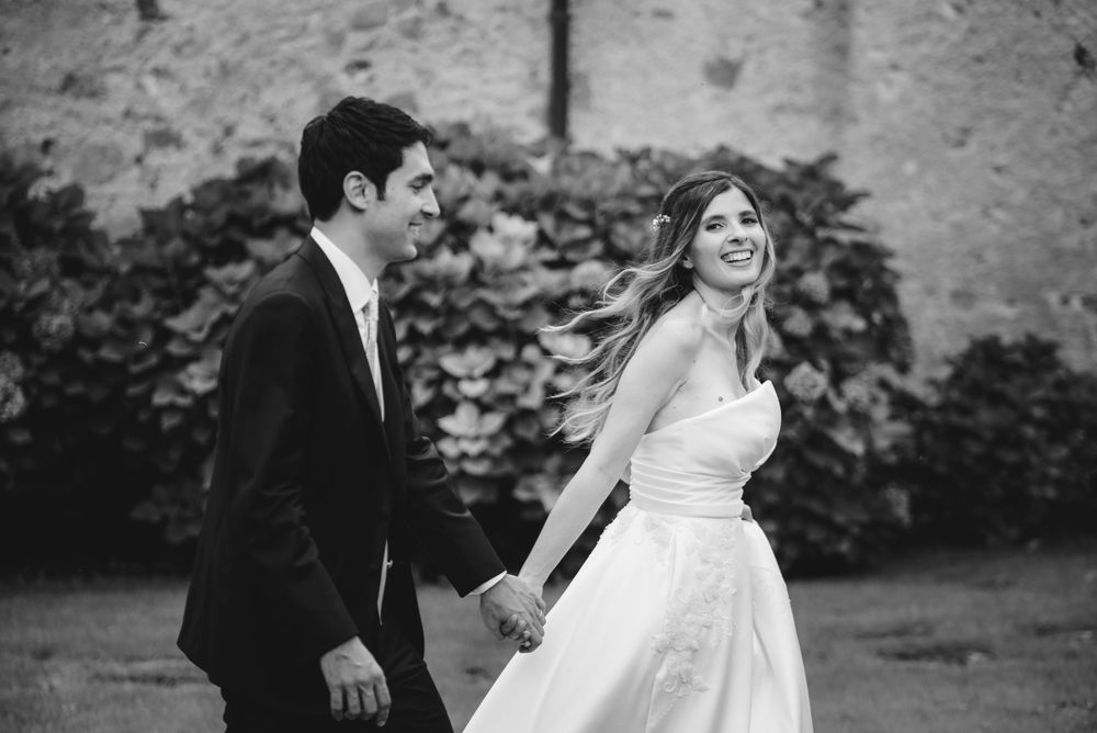 Black and white wedding portraits showcase intimate moments against stone architecture.