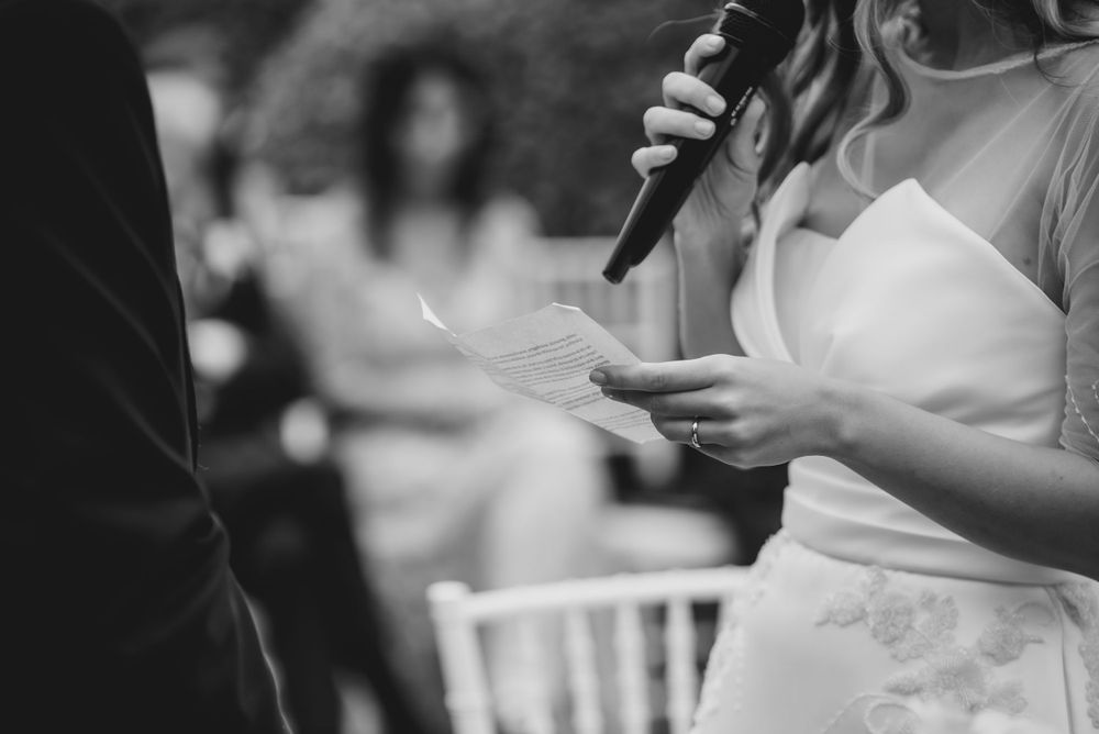 Newlyweds share emotional moments during their wedding ceremony with guests looking on.