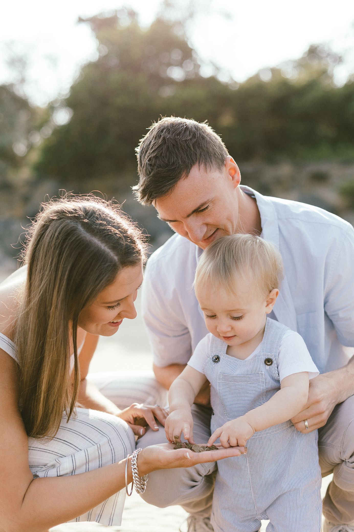 Family shares intimate moments on beach during sunset photography session.
