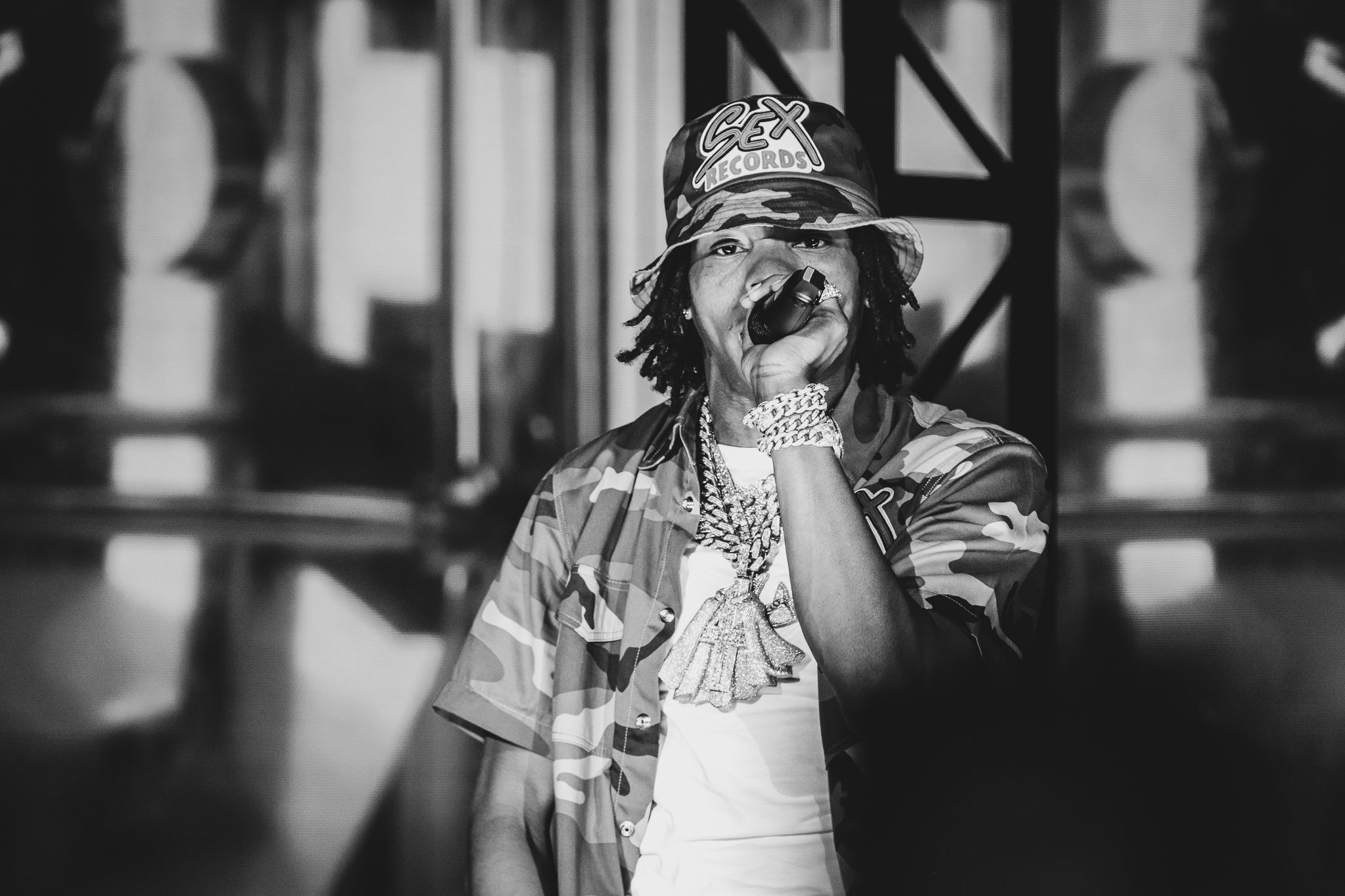 Black and white photo of performer with headband in dramatic stage lighting.